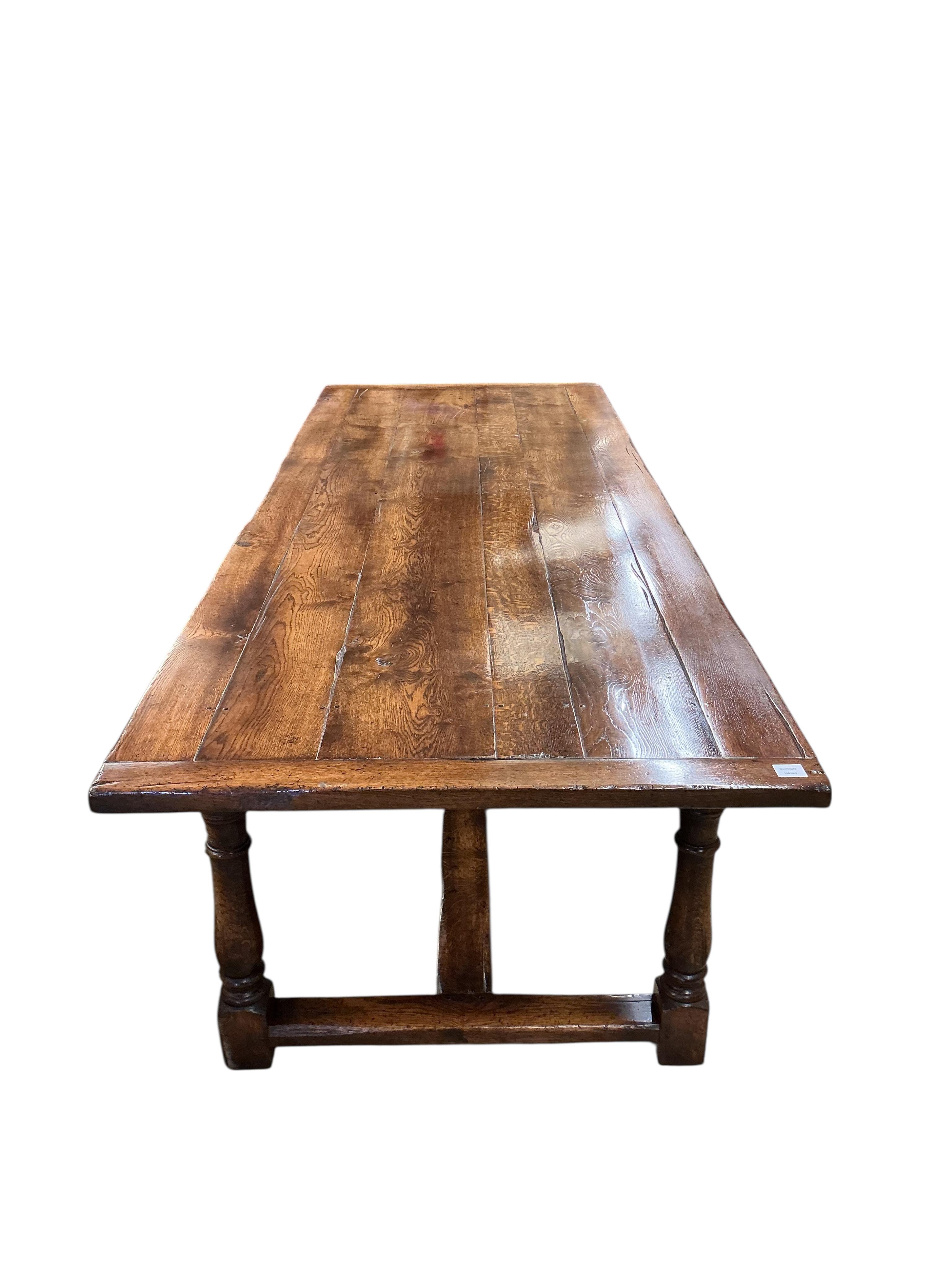 A 17th century style rectangular oak refectory dining table, with cleated six plank top, width 274cm, depth 102cm, height 79cm
